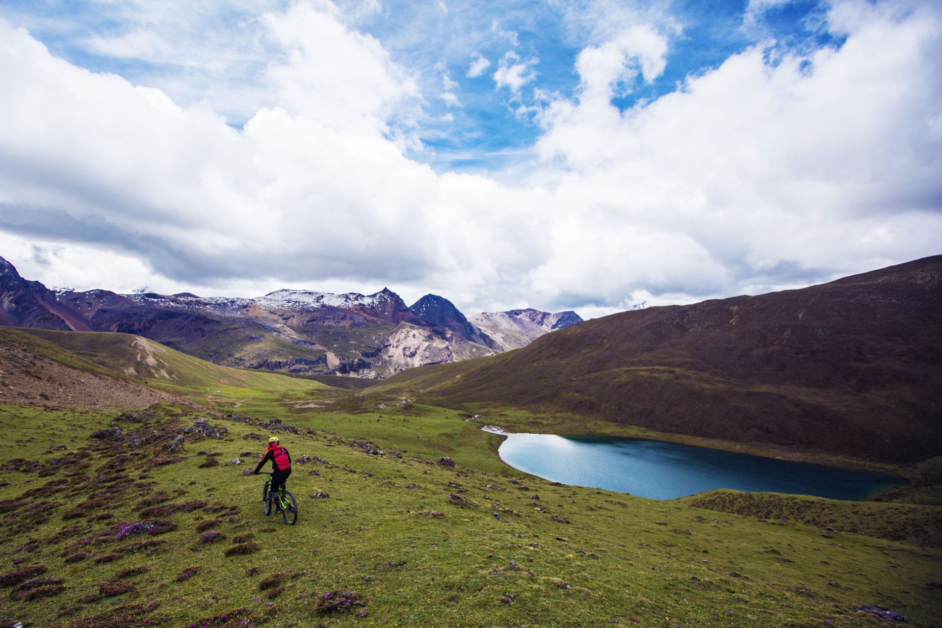 A still alpine lake beneath prayer-flag-strung ridgelines near the Yele La pass in Bhutan